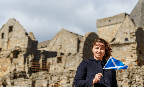 Landlord holding flag in front of property in Scotland